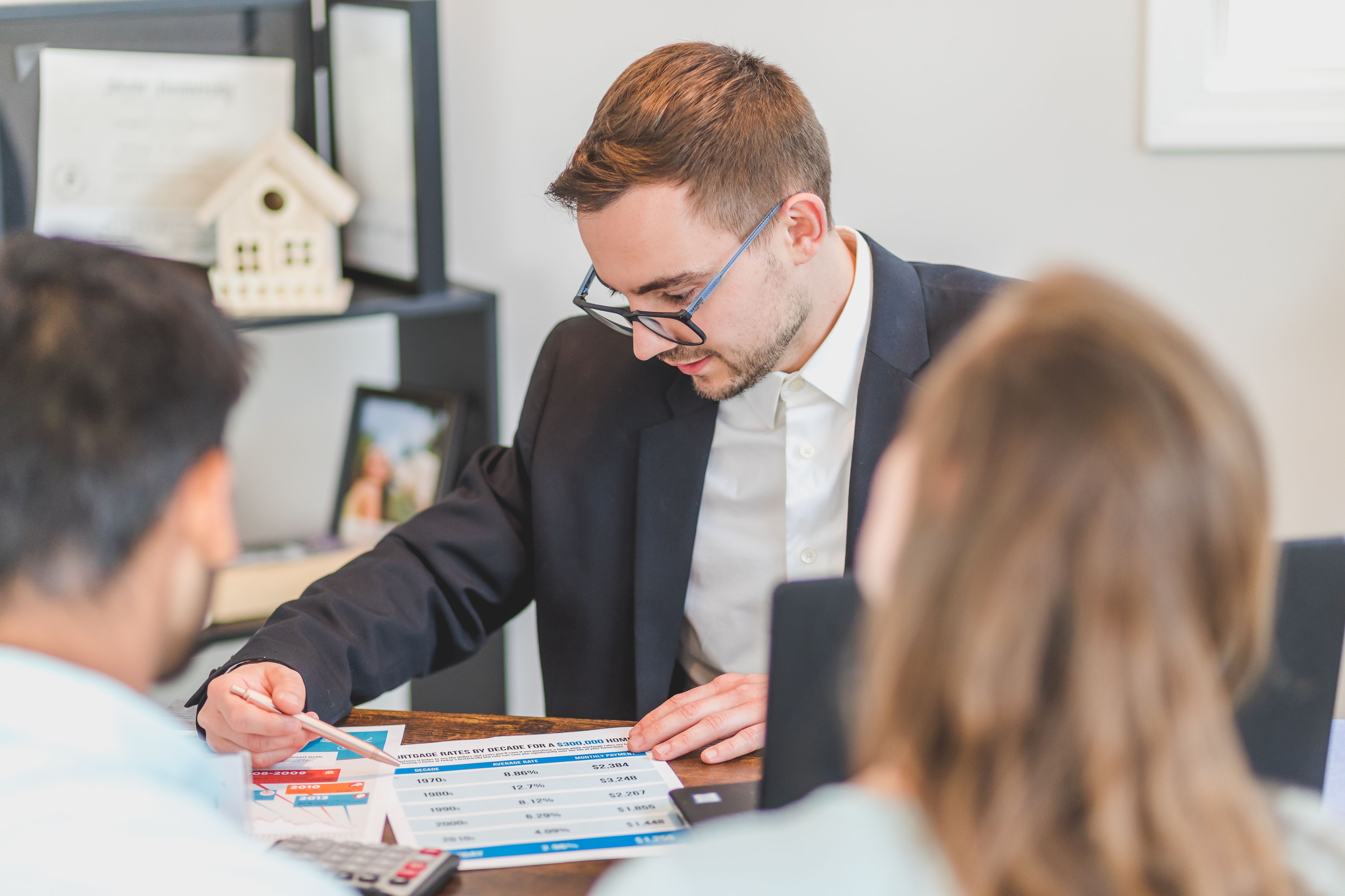 Real estate professional explaining mortgage options to clients in an office
