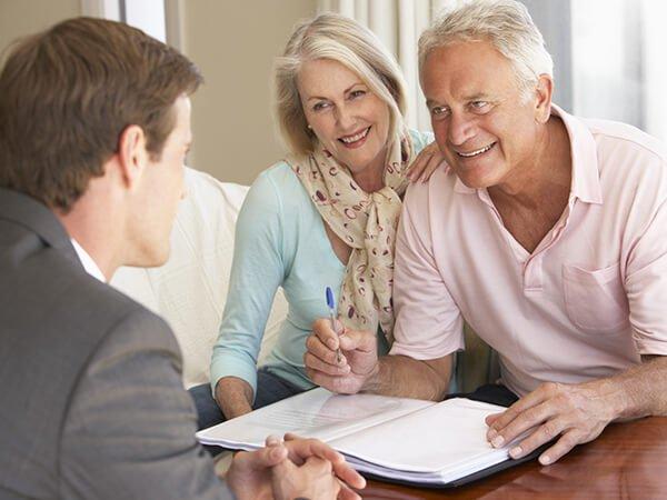 Insurance agent reviewing Medicare plan documents with an elderly couple