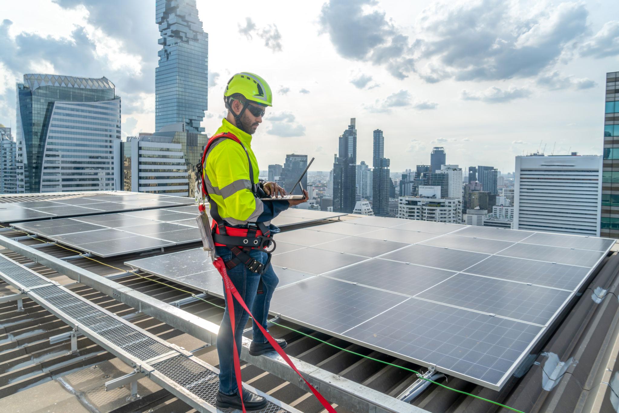 Technician checking solar panels mounted on a residential rooftop